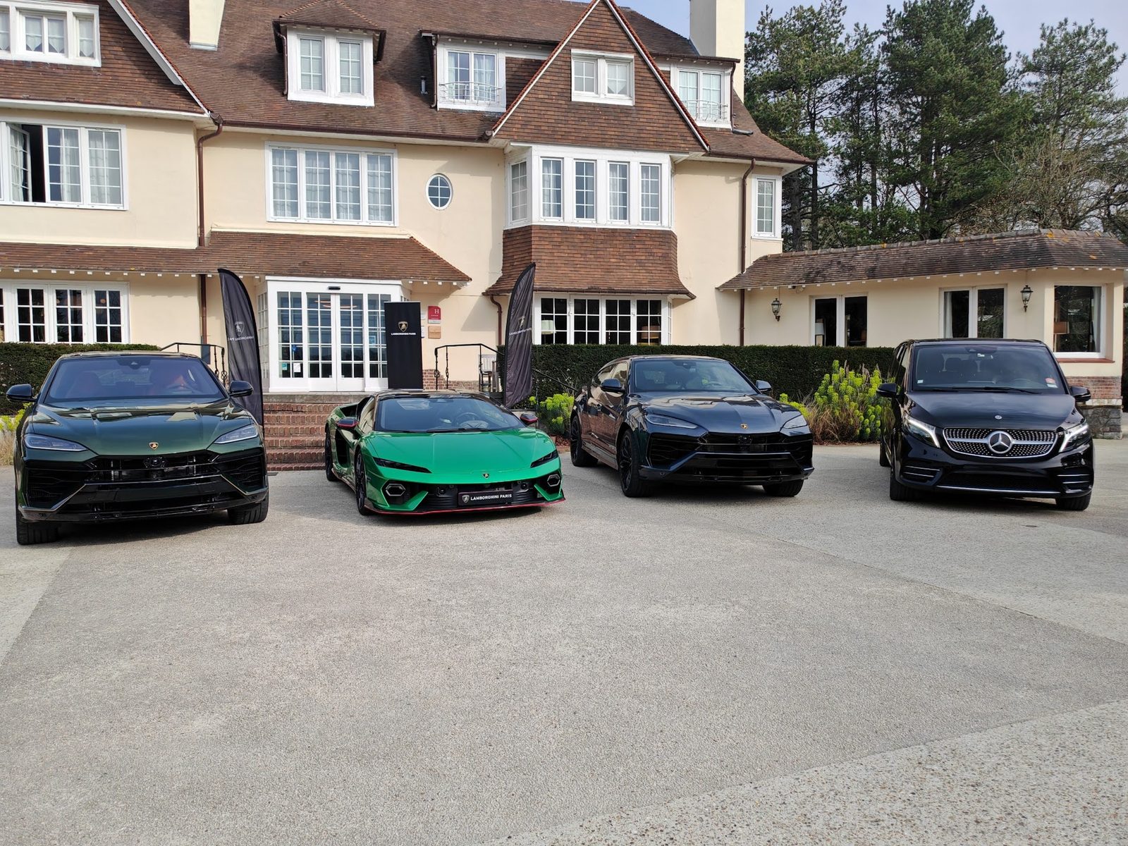 Mercedes Classe V garée devant un manoir avec véhicules de prestige